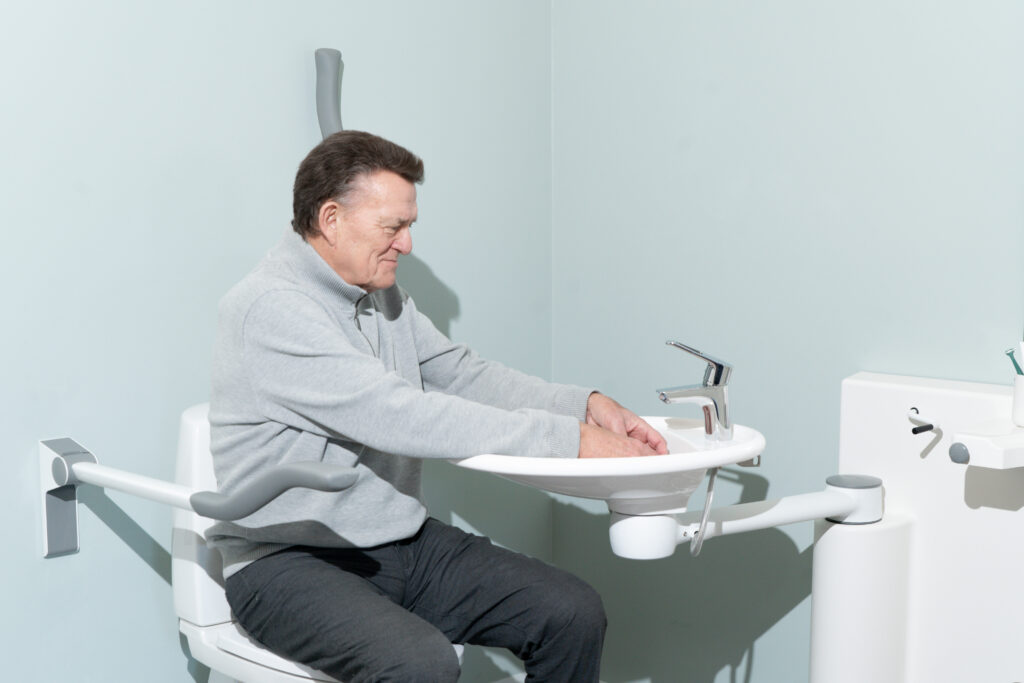 Disabled person at accessible washbasin